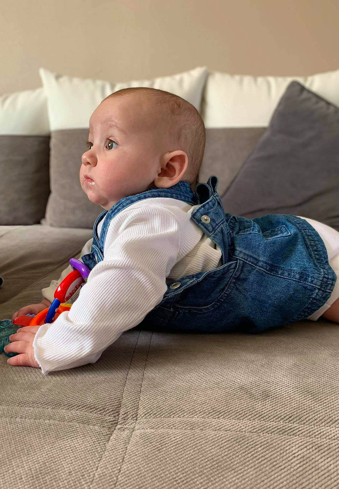 Leona a rejoint le concours — aidez-le/la à gagner de superbes lots ! baby, baby_toddler_clothing, child, comfort, couch, floor, flooring, hardwood, human_leg, knee, linens, pattern, person, room, sitting, sleeve, sock, t_shirt, toddler, wood