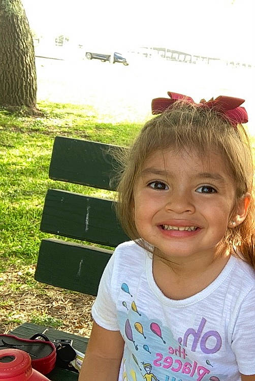 Xena is registered to the contest to win money with this photo: backpack, child, fun, grass, happy, headband, headpiece, iris, jewellery, joy, laugh, leisure, luggage_and_bags, person, plant, recreation, sitting, smile, summer, t_shirt