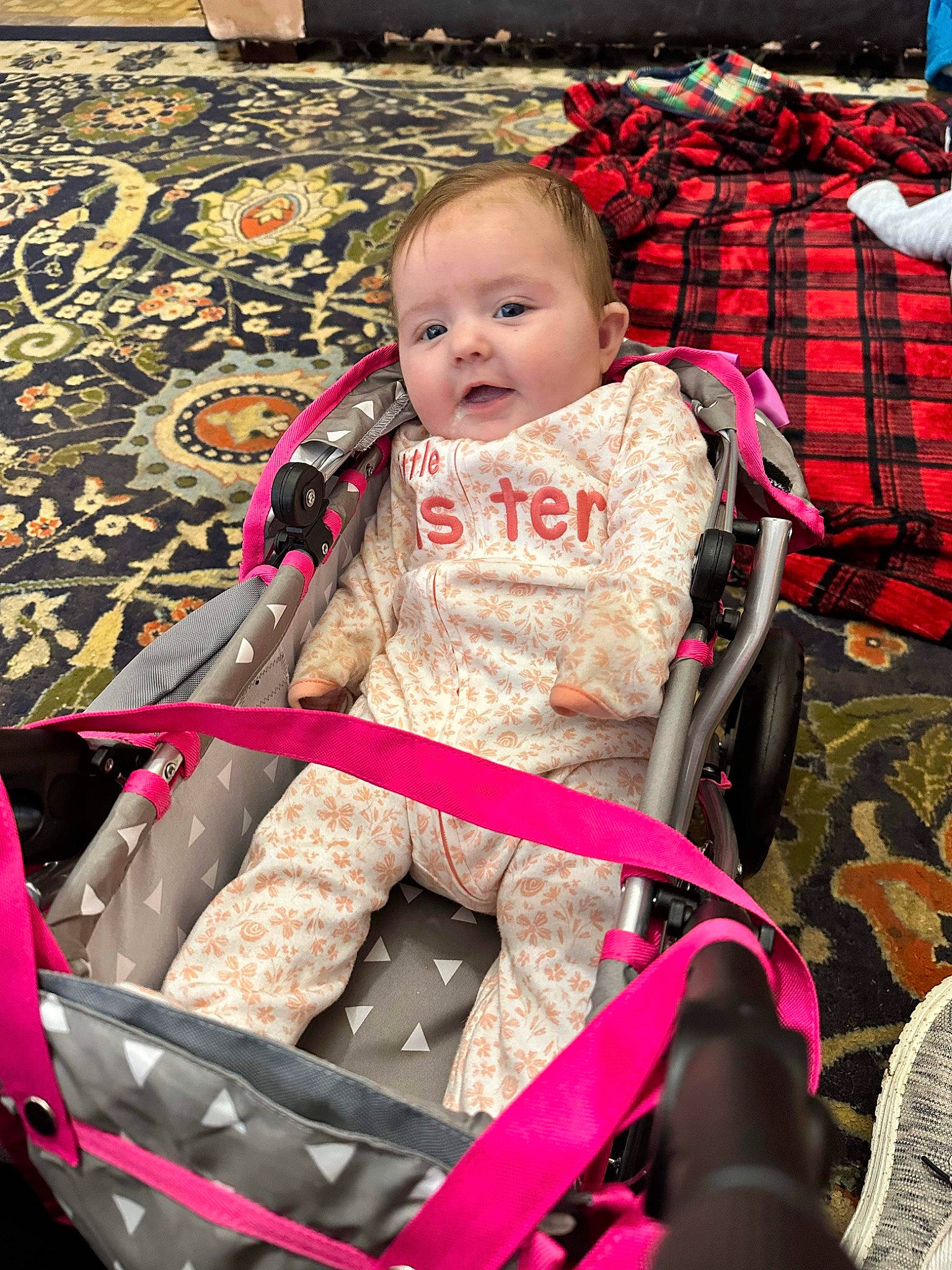 Salem is registered to the contest to win money with this photo: baby, baby_carriage, baby_products, baby_safety, baby_toddler_clothing, carmine, cheek, child, comfort, fun, happy, human_body, lap, magenta, person, pink, plaid, sitting, tartan, toddler
