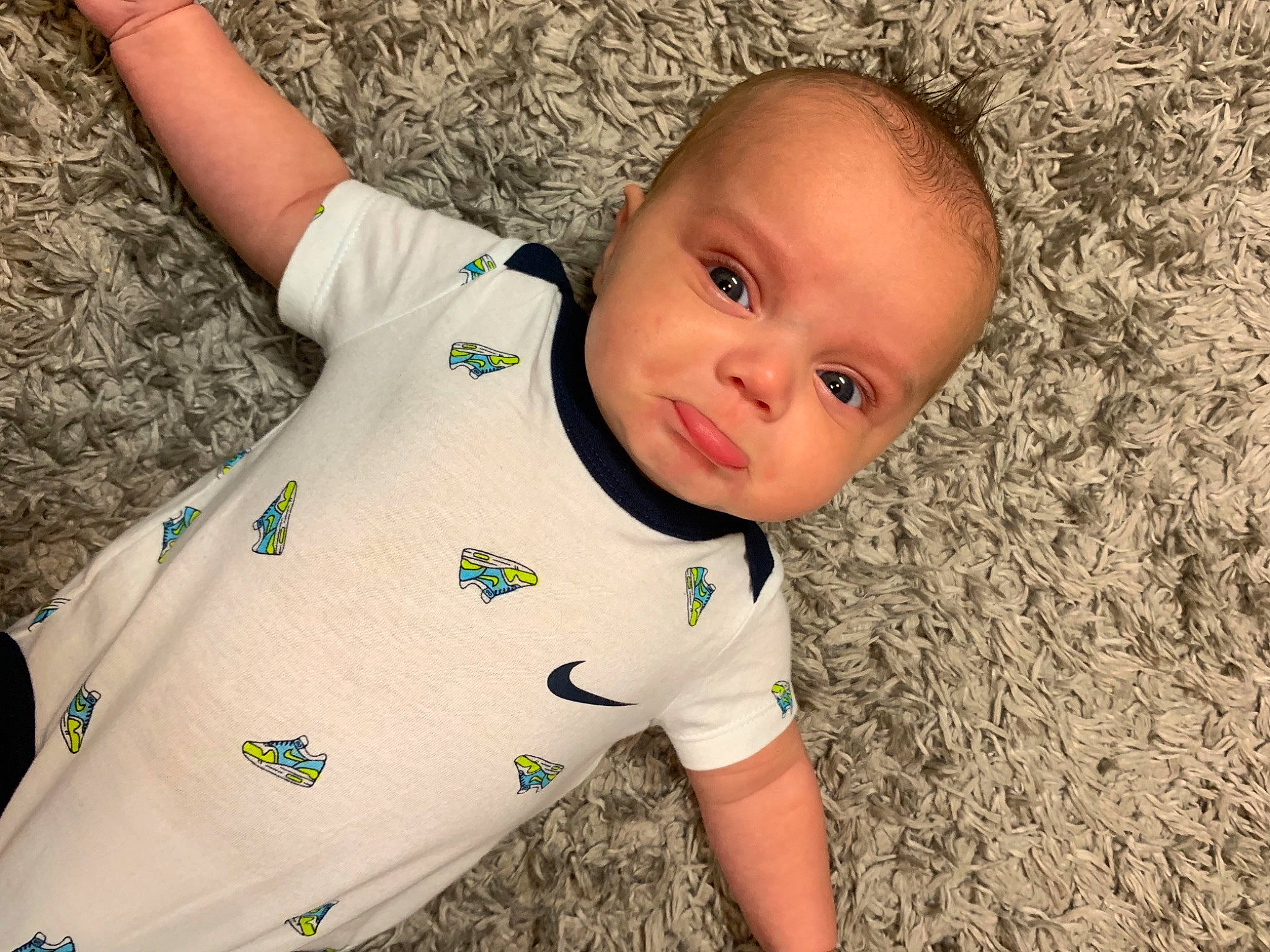Greysen is registered to the contest to win money with this photo: baby, baby_toddler_clothing, cheek, child, comfort, elbow, eye, flooring, fun, grass, happy, pattern, person, sitting, skin, sleeve, soil, t_shirt, toddler, wood