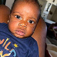 Daemir Jones is registered to the contest to win money with this photo: baby, child, face, eyes, expression, indoor, person, clothing, shirt, animal_print, lap, skin, earrings, curly_hair, portrait, closeup, comfort, background, furniture, home