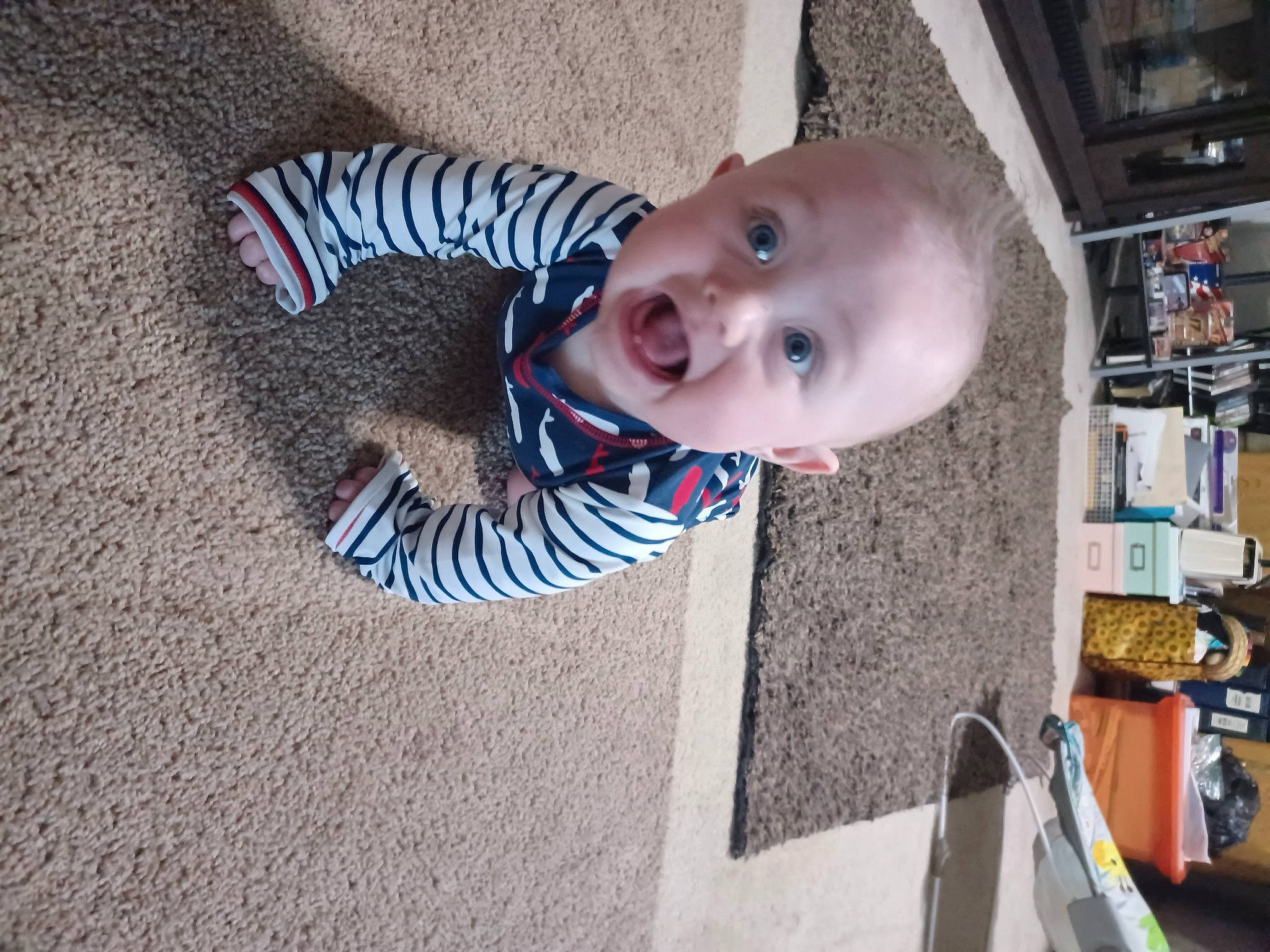 Beckham is registered to the contest to win money with this photo: baby, baby_toddler_clothing, cheek, child, electric_blue, floor, flooring, fun, pattern, person, sitting, smile, surprise, toddler, tree, vacation, wood