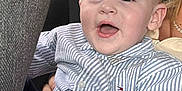 Myles is registered to the contest to win money with this photo: child, toddler, boy, striped_shirt, car_seat, smiling, happy, face, mouth_open, hair, clothing, interior, car, seatbelt, window, daylight, person, portrait, casual, cute