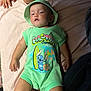 baby, bed, cartoon, casual, child, clothing, cute, family, green, hand, hat, indoors, infant, legs, person, portrait, relaxed, skin, sleepy, surfboard