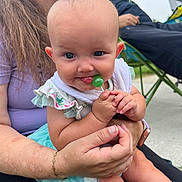 Kadence joined the competition — help win amazing prizes! baby, child, lollipop, hands, person, adult, smile, outdoor, chair, clothing, bracelet, watch, face, skin, head, sitting, happy, toddler, family, casual