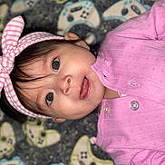 Jimena joined the competition — help win amazing prizes! baby, child, infant, pink_clothing, headband, bow, face, eyes, smile, portrait, closeup, lying_down, blanket, pattern, cute, adorable, toddler, indoors, soft_lighting, baby_girl