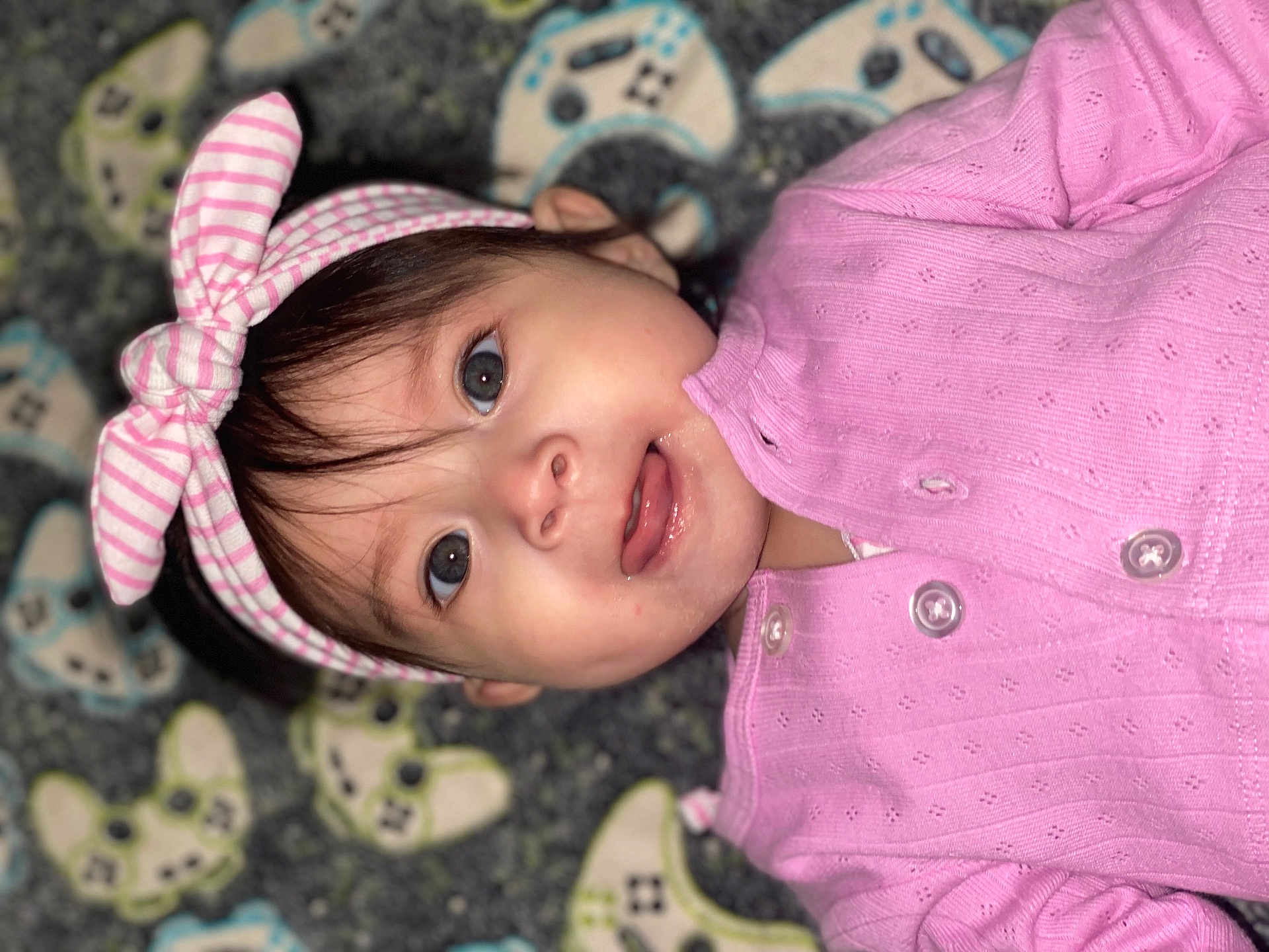 Jimena joined the competition — help win amazing prizes! baby, child, infant, pink_clothing, headband, bow, face, eyes, smile, portrait, closeup, lying_down, blanket, pattern, cute, adorable, toddler, indoors, soft_lighting, baby_girl