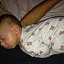 baby, sleeping, onesie, teddy_bear_pattern, bed, pillow, arm, infant, child, soft, cozy, blanket, rest, cute, peaceful, face, head, person, indoor, nap