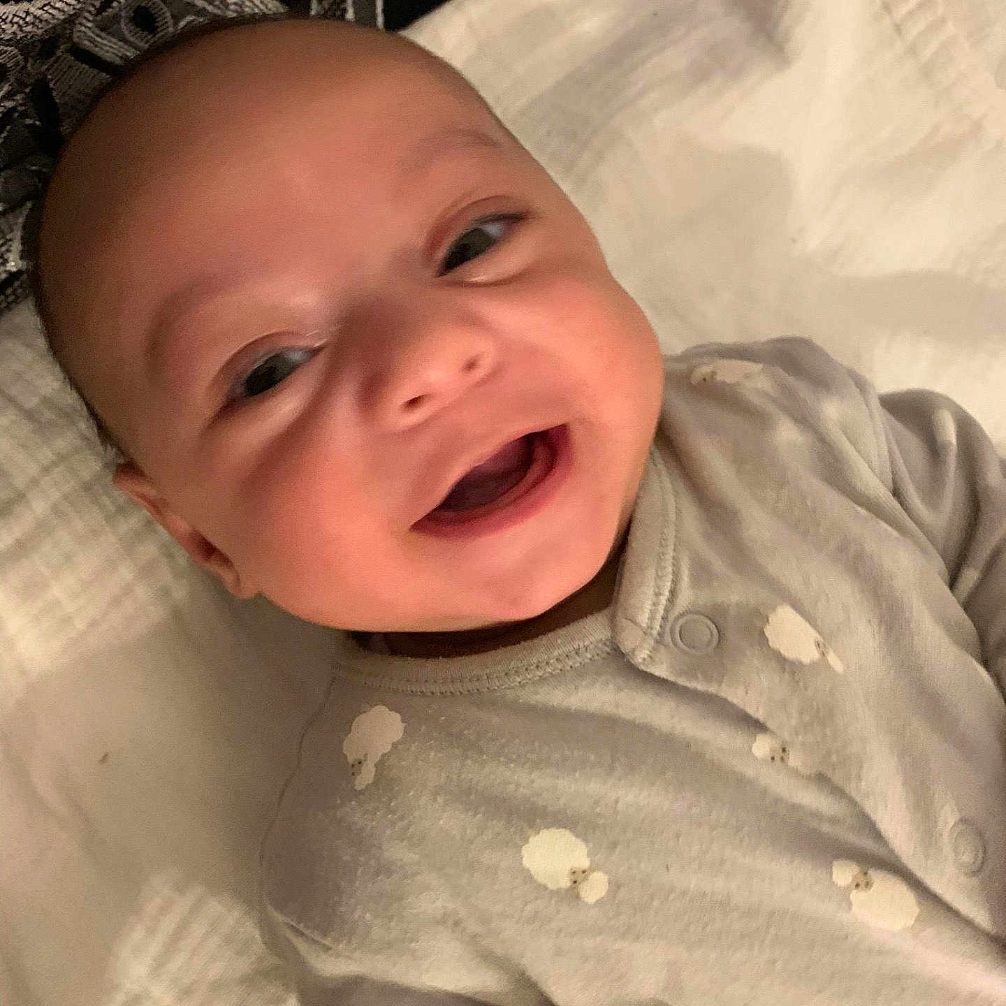 Raith a rejoint le concours — aidez-le/la à gagner de superbes lots ! apparel, baby, blanket, child, closeup, cloud_pattern, comfort, cute, fabric, face, happy, head, indoors, infant, lying_down, onesie, person, pillow, smiling, soft_texture