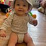 Myla participe au concours pour gagner de l'argent avec cette photo : baby, child, hat, onesie, floor, wooden_floor, smiling, indoor, toy, furniture, window, light, person, cute, happy, home, infant, sitting, face, headwear