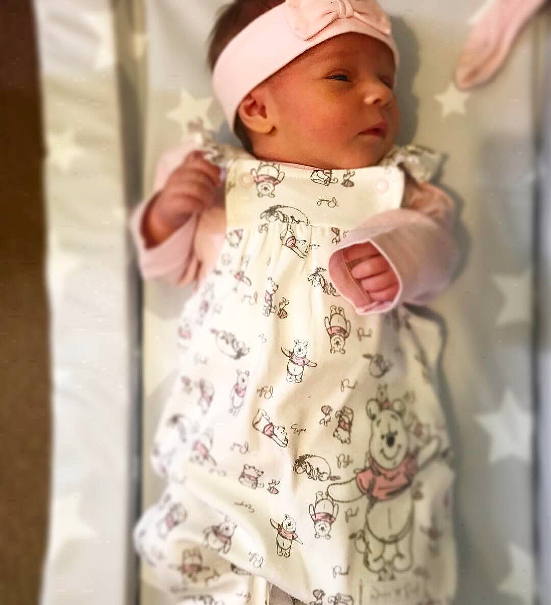 Elsa is registered to the contest to win money with this photo: baby, beige, child, clothing, dress, headgear, headwear, outerwear, person, sleeve, smile, toddler