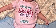 Emersyn is registered to the contest to win money with this photo: baby, infant, smiling, onesie, pink_clothing, blanket, bed, socks, cute, happy, child, lying_down, indoor, person, face, head, legs, skin, expression, cozy