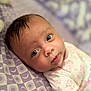 Emersyn is registered to the contest to win money with this photo: baby, infant, face, eyes, tongue, blanket, pattern, purple, white_clothing, cute, lying_down, soft_light, skin, head, expression, newborn, person, child, indoors, portrait