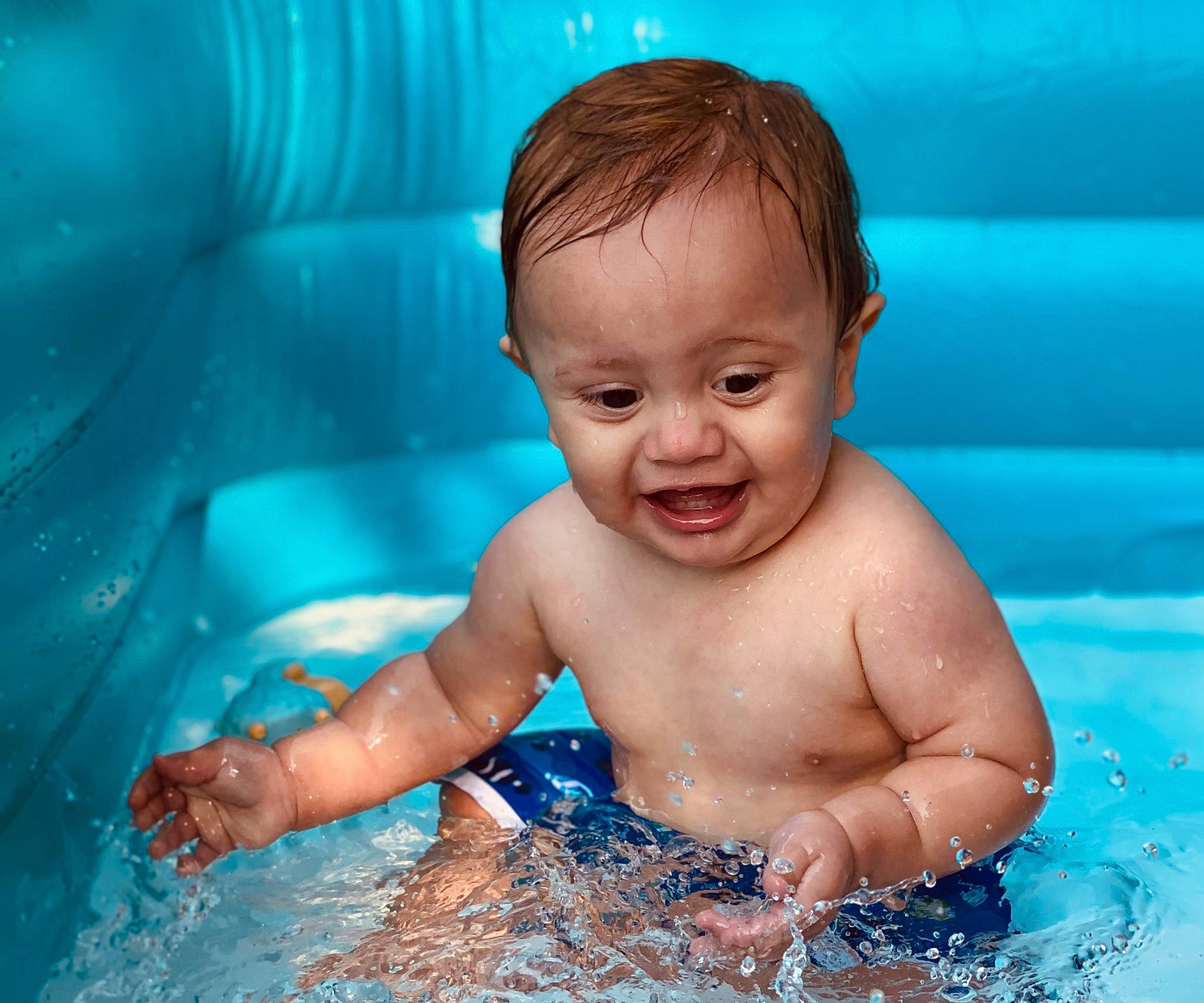 Branson is registered to the contest to win money with this photo: aqua, azure, baby, baby_bathing, bathing, blue, cheek, fluid, fun, happy, iris, leisure, muscle, nose, organ, person, photograph, skin, smile, swimming_pool