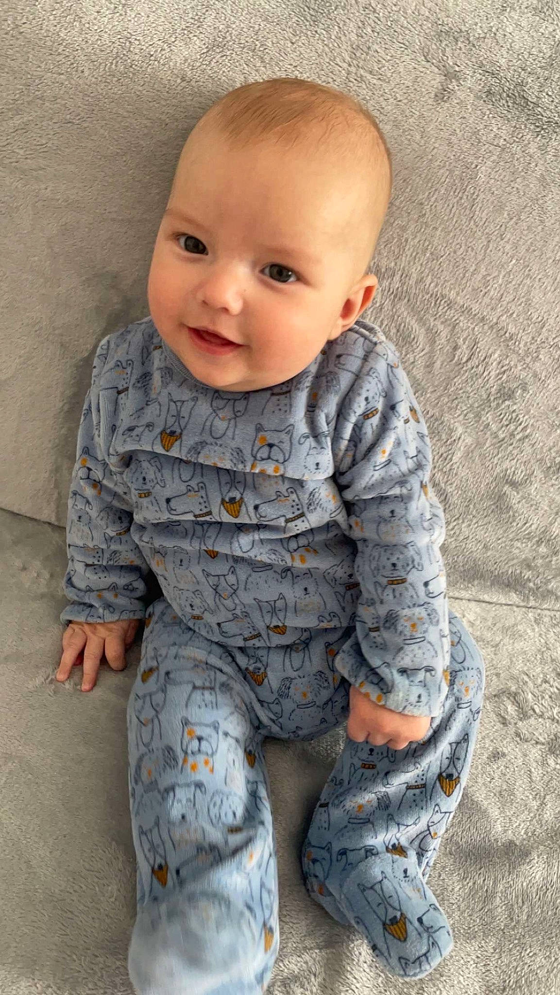 Lenny participe au concours pour gagner de l'argent avec cette photo : baby, baby_toddler_clothing, cheek, child, eye, face, flooring, grey, head, human_body, iris, lip, neck, pattern, person, sitting, skin, sleeve, smile, toddler