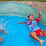 child, swimming, pool, outdoor, summer, water, splashing, smiling, laughing, happy, playful, backyard, grass, swimwear, t_shirt, shorts, wet, recreation, family, portrait