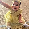 baby, child, smiling, yellow_dress, headband, sitting, carpet, rug, sock, happy, indoors, person, footwear, patterned_rug, cute, infant, toddler, clothing, reaching, portrait