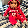 Divinity joined the competition — help win amazing prizes! baby, child, hoodie, pink_clothing, bed, striped_bedspread, sitting, indoors, person, face, cute, young_child, socks, portrait, curious_expression, cozy, room, casual_clothing, headwear, young_infant