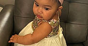 Divinity is registered to the contest to win money with this photo: adorable, baby, chair, child, clothing, curly_hair, cute, dress, fashion, flower, girl, headband, indoors, leather, looking_away, portrait, seat, sitting, sparkly, young