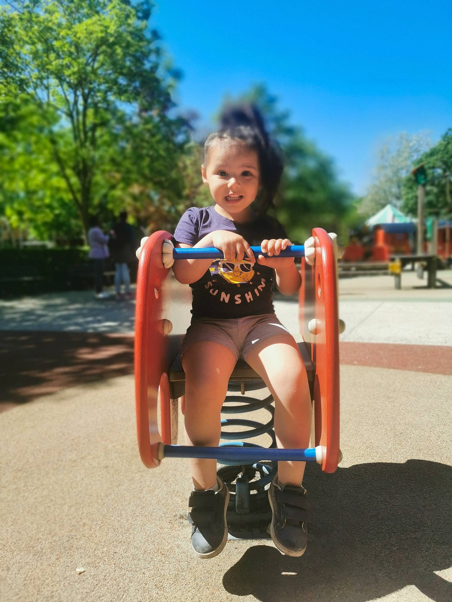 Lya participe au concours pour gagner de l'argent avec cette photo : asphalt, city, dress, fun, grass, happy, human_leg, knee, leg, leisure, outdoor_play_equipment, person, playground, recreation, shorts, sky, smile, summer, thigh, toddler