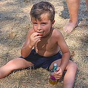 Ethan a rejoint le concours — aidez-le/la à gagner de superbes lots ! child, boy, snack, juice, outdoor, grass, barefoot, summer, casual, sitting, sunlight, shadow, person, legs, sandals, nature, relaxed, young, dry_grass, daytime