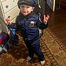 child, toddler, police_costume, blue_uniform, hat, indoor, rug, carpet, furniture, dresser, door, flooring, toy, bag, person, clothing, smiling, pose, home, play