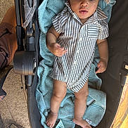 Messiah is registered to the contest to win money with this photo: baby, casual, child, comfort, curious, fabric, face, footwear_free, hand, hat, headwear, indoors, infant, legs, portrait, relaxation, skin, striped_clothing, stroller, towel