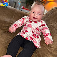 Serenity is registered to the contest to win money with this photo: baby, smiling, couch, indoor, lamp, clothing, pants, happy, infant, face, foot, hand, toy, furniture, portrait, child, cozy, home, warm_light, relaxed