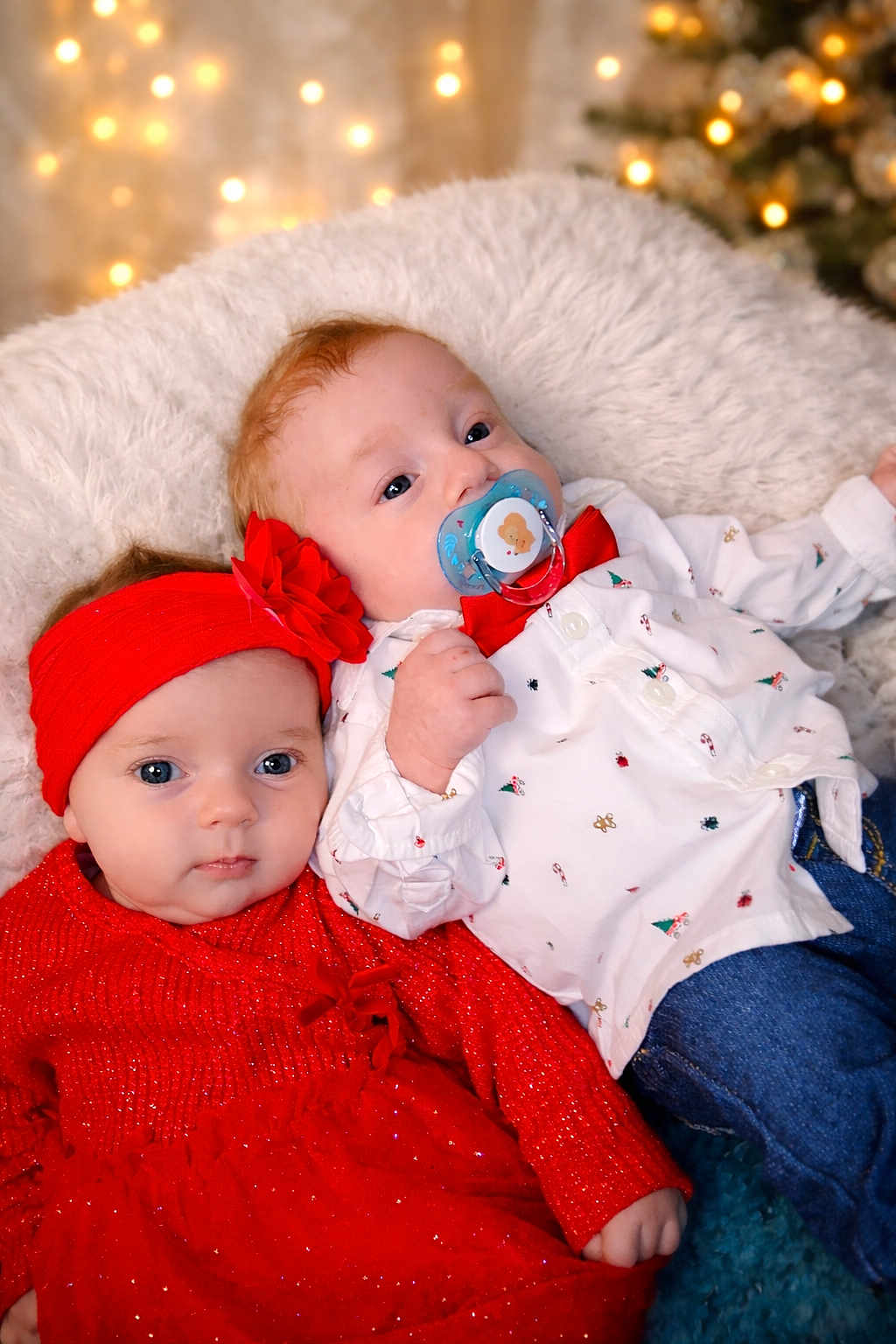 Coline Et Matthew a rejoint le concours — aidez-le/la à gagner de superbes lots ! baby, infant, red_dress, headband, flower, pacifier, bow_tie, white_shirt, jeans, cushion, fluffy, holiday, christmas, twinkle_lights, portrait, two_babies, cute, cozy, indoor, soft_lighting