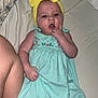 Josetta joined the competition — help win amazing prizes! baby, child, infant, yellow_headband, blue_dress, bed, pacifier, tattoo, skin, hand, face, person, lying_down, indoors, bed_sheet, expression, cute, fingertouch, headwear, barefoot