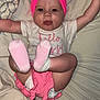 baby, infant, pink_headband, pink_shorts, socks, tongue_out, lying_down, bed, blanket, playful, child, cute, happy, clothing, person, face, arms_up, feet, diaper, home