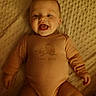 Everleigh joined the competition — help win amazing prizes! baby, child, smiling, onesie, brown_clothing, lying_down, blanket, happy, cute, infant, face, portrait, indoors, soft_texture, warm_lighting, chubby_arms, chubby_legs, head, person, cozy