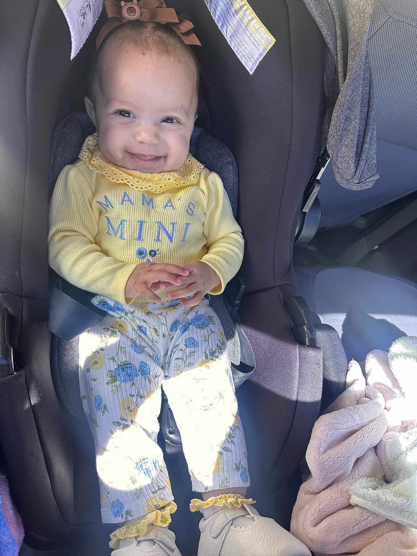 Aveah is registered to the contest to win money with this photo: baby, infant, child, car_seat, smiling, yellow_clothing, mamas_mini, headband, bow, floral_pants, blanket, shoes, sunlight, car_interior, seat_belt, hands, portrait, happy, cozy, closeup