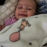 baby, blanket, cushion, smile, happy, infant, face, child, soft, cute, comfort, cozy, pink_clothing, giraffe_cartoon, lying_down, home, portrait, young_child, baby_girl, wrapped