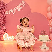 Neveah joined the competition — help win amazing prizes! baby, child, birthday, cake, pink, dress, balloons, flowers, celebration, smiling, portrait, cute, decorations, happy, sitting, indoor, party, girl, pigtails, footwearless