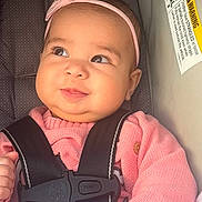Amara joined the competition — help win amazing prizes! baby, blanket, car_seat, child, closeup, cozy, cute, face, hand, headband, indoor, infant, pink_sweater, portrait, safety_harness, seat, smile, soft_lighting, warning_label, young_child