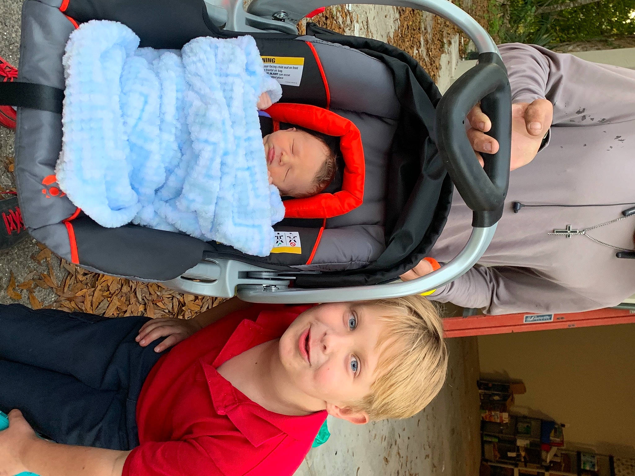 Kodi joined the competition — help win amazing prizes! baby, baby_carriage, baby_products, baby_toddler_clothing, car_seat, child, clothing, comfort, fun, green, joy, lap, leisure, orange, person, plant, red, shelf, sitting, smile