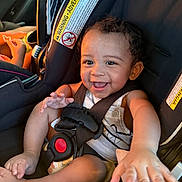 Dj is registered to the contest to win money with this photo: baby, car_seat, smiling, child, seatbelt, happy, infant, safety, person, cute, car_interior, clothing, seat, toddler, secure, joy, young, face, hand, expression