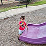 Noah Carter joined the competition — help win amazing prizes! child, boy, playground, slide, toy, wood_chips, outdoor, fence, grass, tree, sidewalk, smiling, shorts, tshirt, shoes, daytime, recreation, happy, person, playing