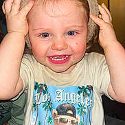 Dryker is registered to the contest to win money with this photo: animal_ears, baby, blond_hair, blue_eyes, child, clothing, cute, expression, face, graphic_tshirt, hands, happy, hat, indoor, person, playful, portrait, smiling, toddler, tshirt