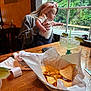 Aubriella is registered to the contest to win money with this photo: baby, child, adult, headband, window, greenery, tree, table, wood, chips, basket, drink, margarita, lime, glass, napkin, restaurant, indoor, person, food