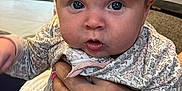 Aubriella is registered to the contest to win money with this photo: baby, infant, face, headband, hand, nail_polish, bracelet, heart_charm, floral_pattern, clothing, indoors, couch, person, portrait, cute, child, expression, soft_lighting, closeup, holding