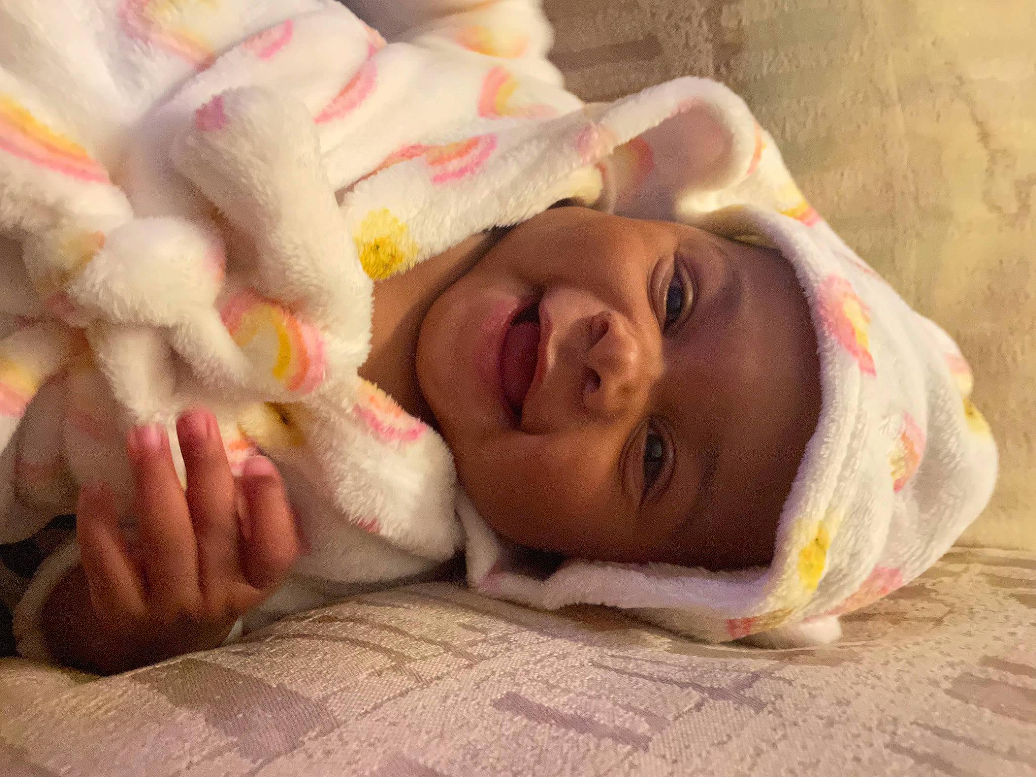 Hazelyn is registered to the contest to win money with this photo: baby, bedding, bedtime, child, comfort, face, fur, gesture, happy, headwear, human_body, linens, lip, mouth, nail, nose, person, petal, room, skin