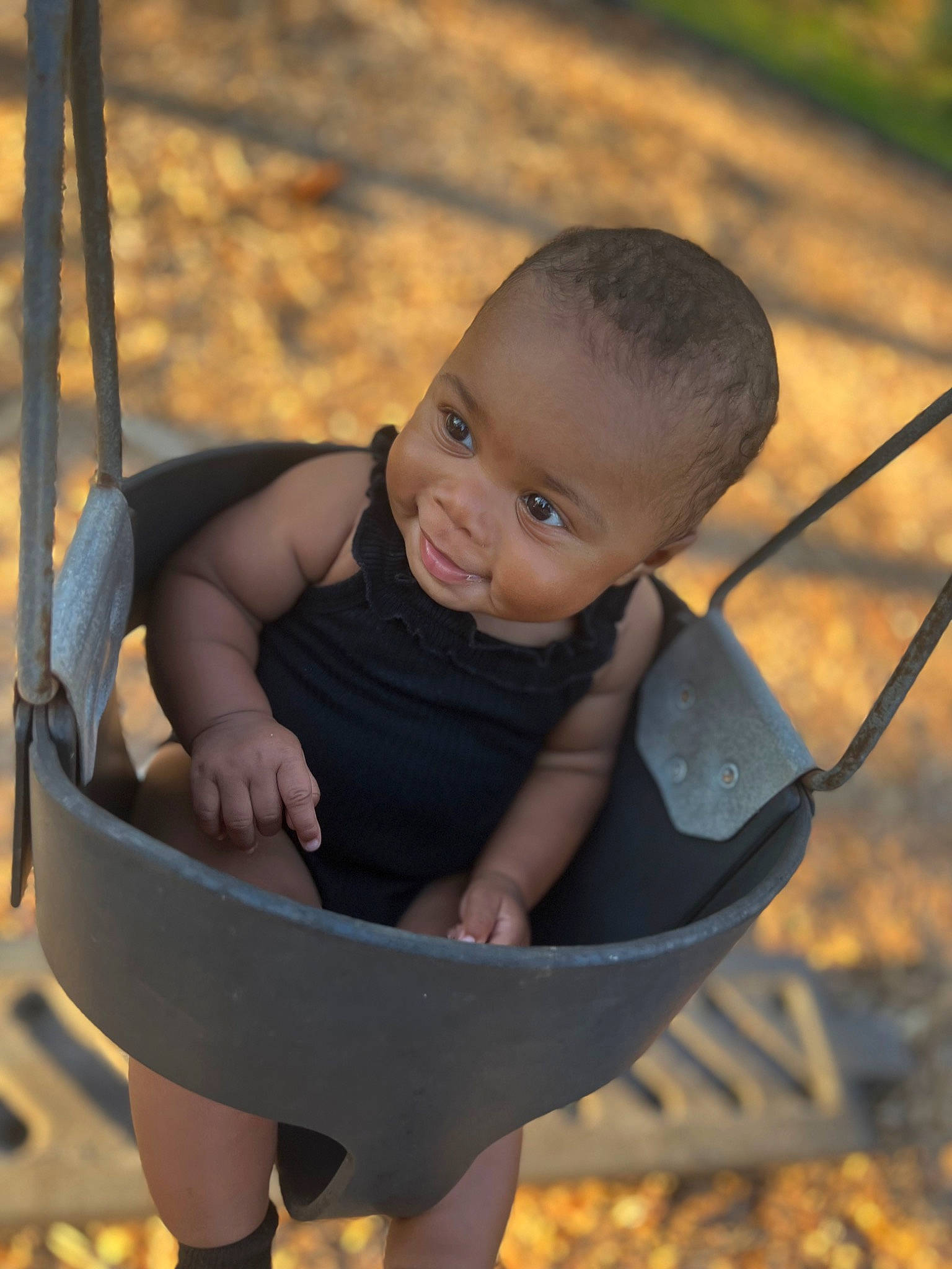 Hazelyn is registered to the contest to win money with this photo: arm, baby, black, chair, cheek, eye, facial_expression, finger, grass, hand, happy, head, human_body, leaf, leg, people_in_nature, person, skin, smile, swing