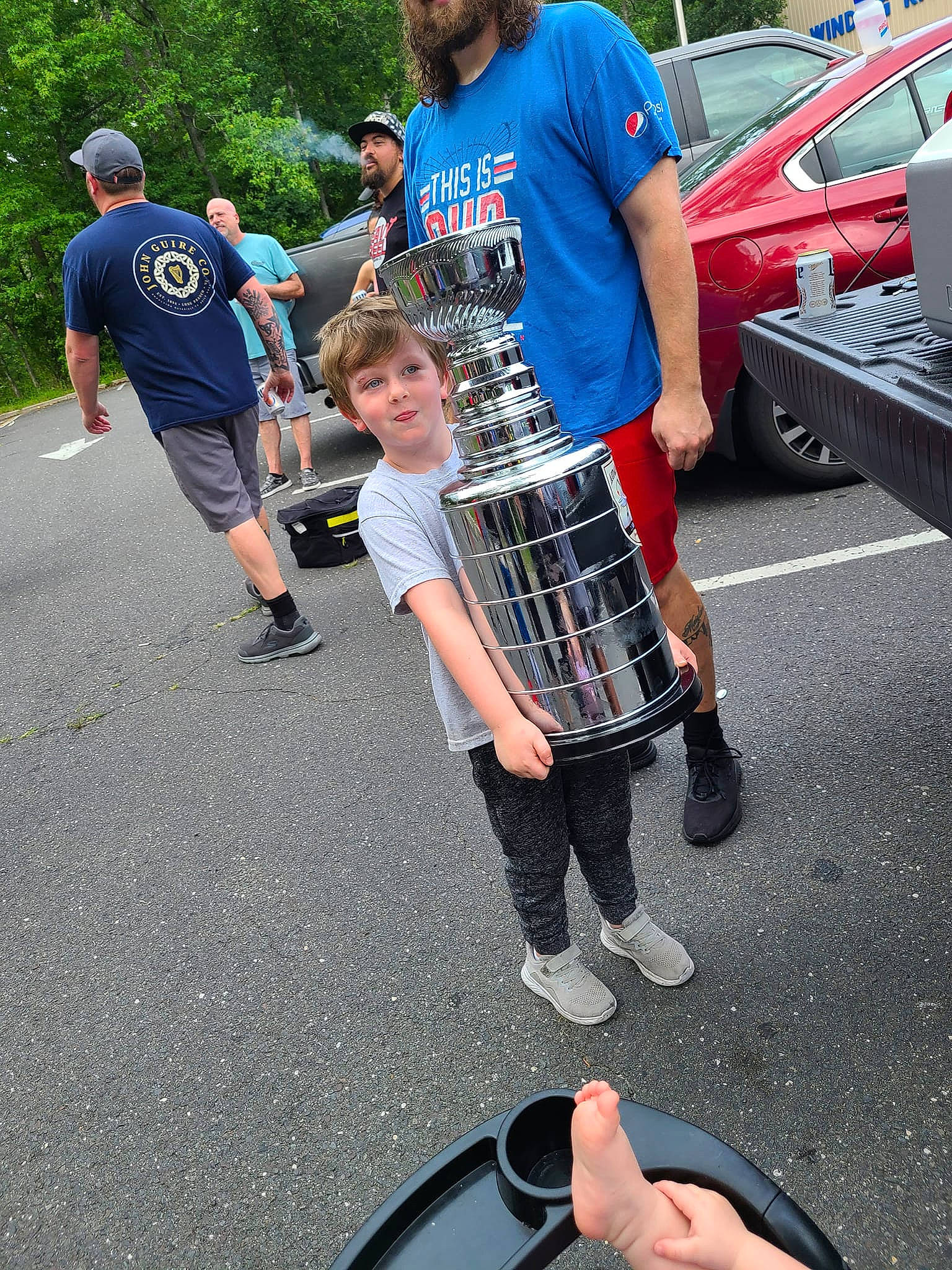 Archer is registered to the contest to win money with this photo: asphalt, car, event, fun, headwear, human_leg, kilt, leisure, motor_vehicle, musical_instrument, pattern, person, plaid, recreation, shoe, shorts, sneakers, t_shirt, tartan, thigh