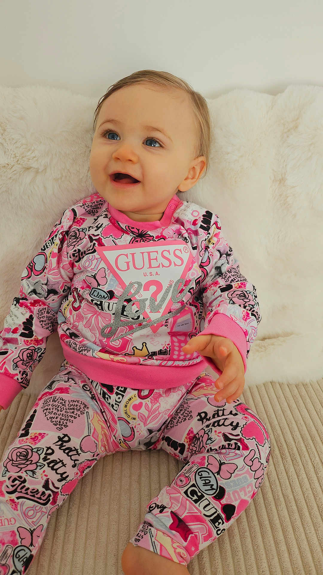 Valentina a rejoint le concours — aidez-le/la à gagner de superbes lots ! baby, child, pink_clothing, patterned_outfit, sitting, happy, blue_eyes, indoor, soft_texture, couch, plush, portrait, cute, infant, smiling, fashion, comfortable, closeup, young, cozy