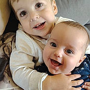 Ethan participe au concours pour gagner de l'argent avec cette photo : child, baby, smiling, hug, couch, happy, indoors, sibling, cute, portrait, clothing, face, hand, eyes, infant, toddler, warm, cozy, family, love
