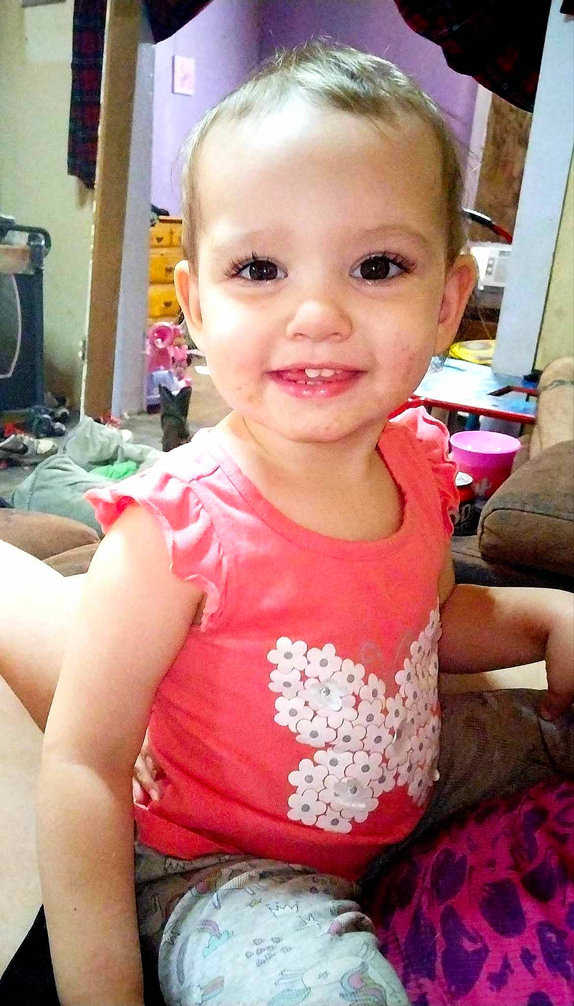 Dorothy is registered to the contest to win money with this photo: baby_toddler_clothing, cheek, child, eye, eyelash, finger, fun, hairstyle, happy, joy, lip, magenta, mouth, nose, person, pink, sitting, skin, sleeve, smile