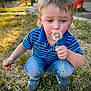 child, boy, dandelion, grass, outdoor, nature, flower, blue_shirt, crouching, curious, daylight, casual_clothing, short_hair, greenery, yard, summer, plant, toy_bucket, portrait, young_child