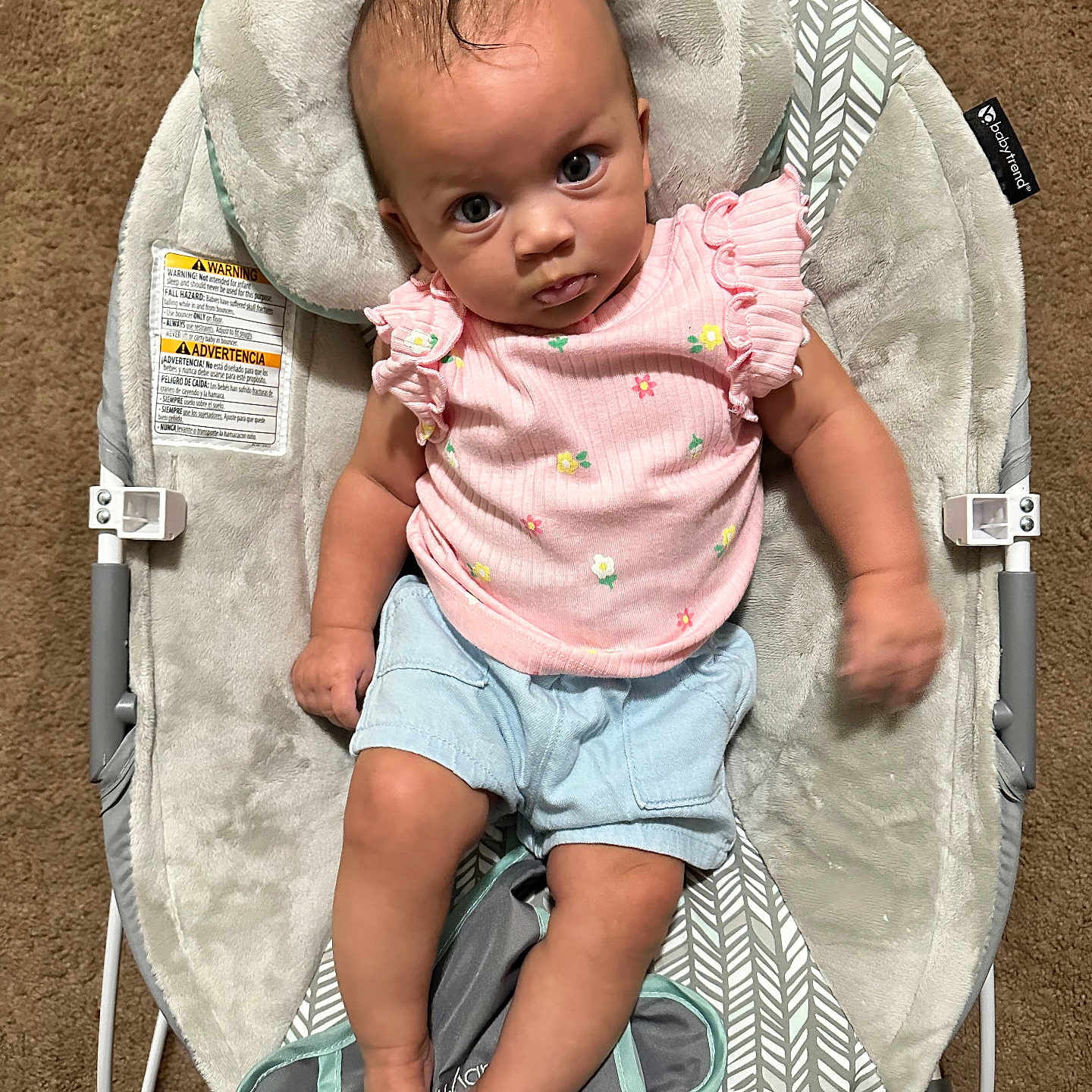 Rayne joined the competition — help win amazing prizes! baby, infant, child, baby_rocker, pink_shirt, blue_shorts, carpet, plush_cushion, patterned_fabric, footwear, barefoot, indoor, cute, portrait, seated, looking_up, curious_expression, soft_texture, baby_clothing, small_hands